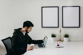 The Best 5 Freelancing Jobs Online for Beginners: Your Complete Guide to Getting Started Freelancing 4 A young freelancer sitting at a desk with a laptop, coffee, and notebook, working from home in a cozy workspace.